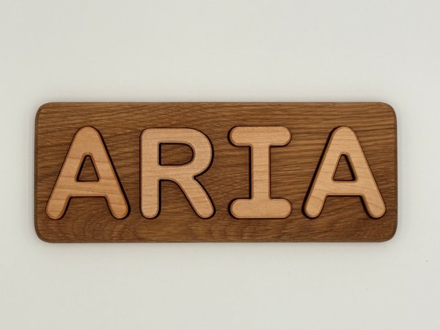 Finished ARIA puzzle with light letters and a darker grained board