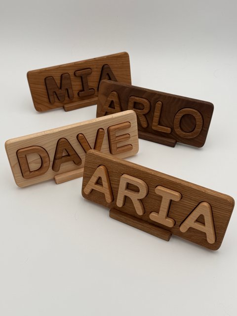 Four finished one-row puzzles reading MIA, ARLO, DAVE and ARIA on separate stands