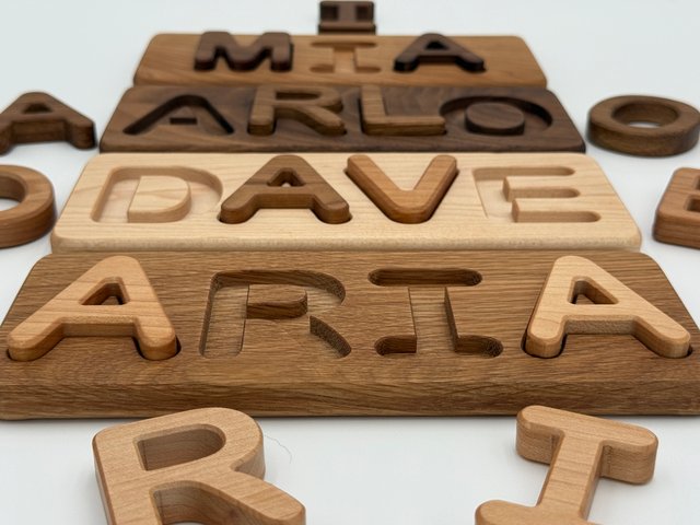 Close-up of removable letters beside their puzzle boards, showing grain and matching recesses