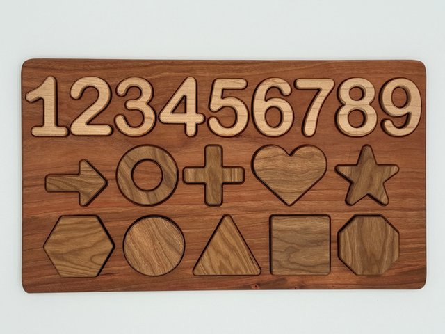 Finished three-row wooden puzzle with numbers 1 through 9, arrow, ring, cross, heart and star in the middle row, and hexagon, circle, triangle, square and octagon below